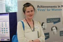 Catherine stood in front of LMS banner wearing white top and blue lanyard